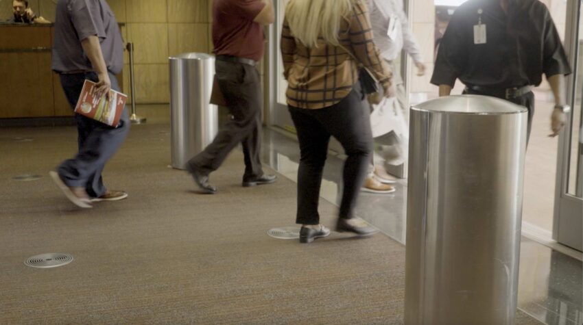 Two people entering through SafePointe weapons detection bollards.